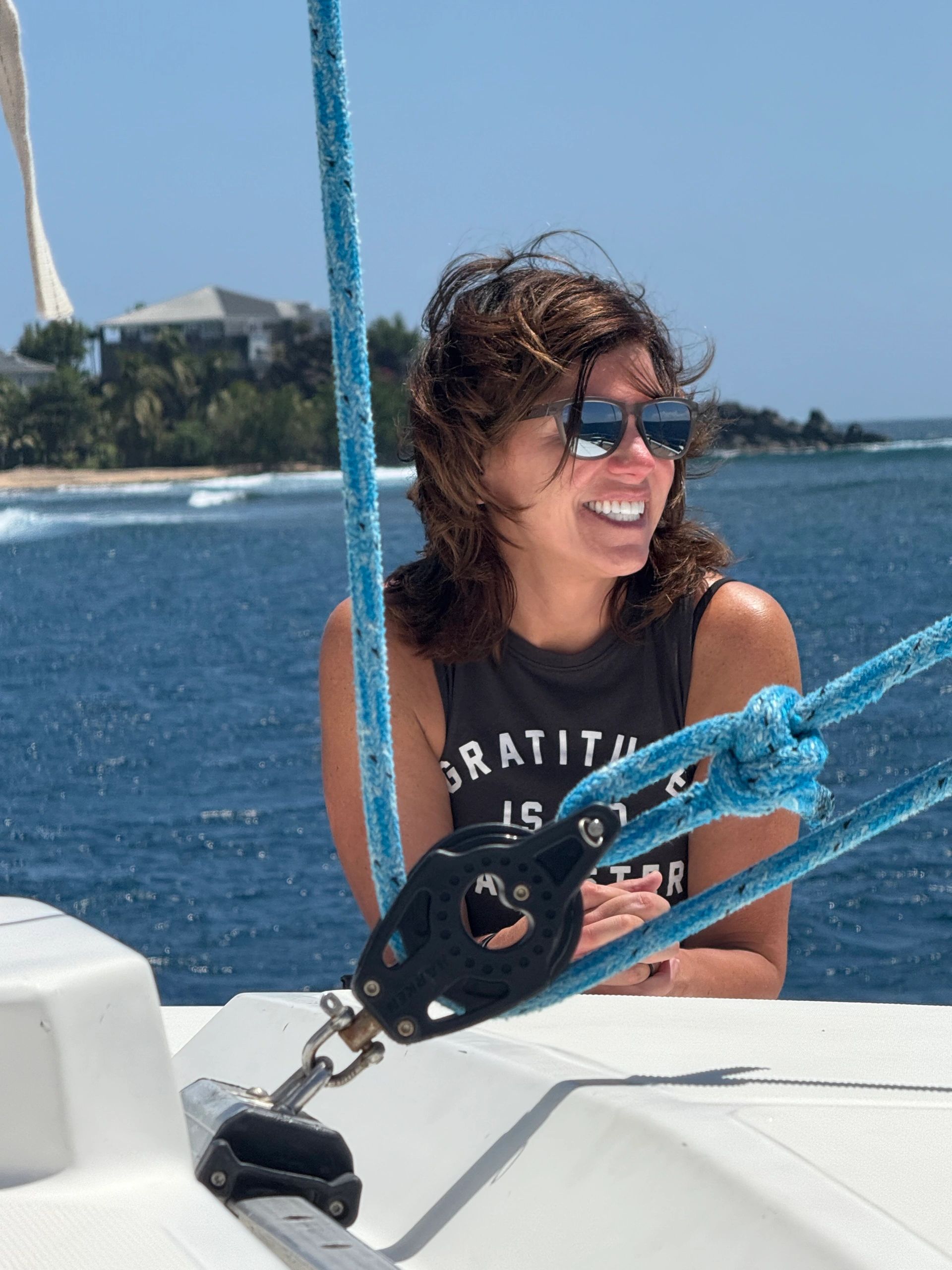 A smiling guest enjoying a day on the sailing catamaran