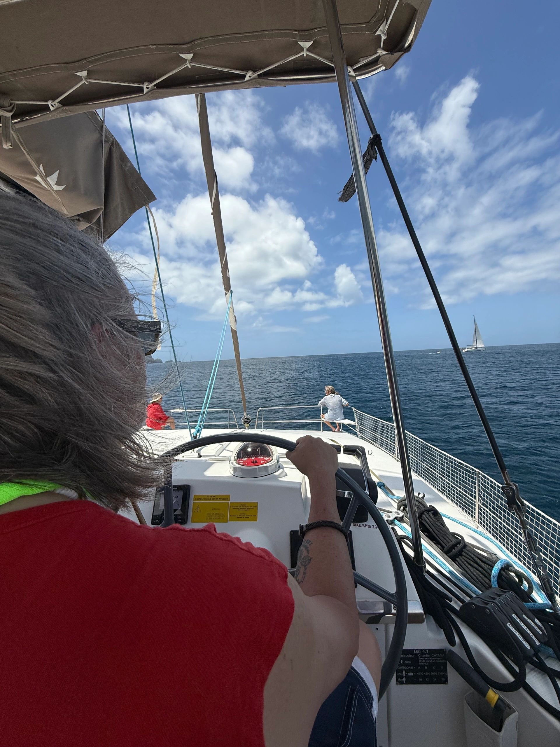 Looking forward from the helm of a sailing catamaran toward the sea