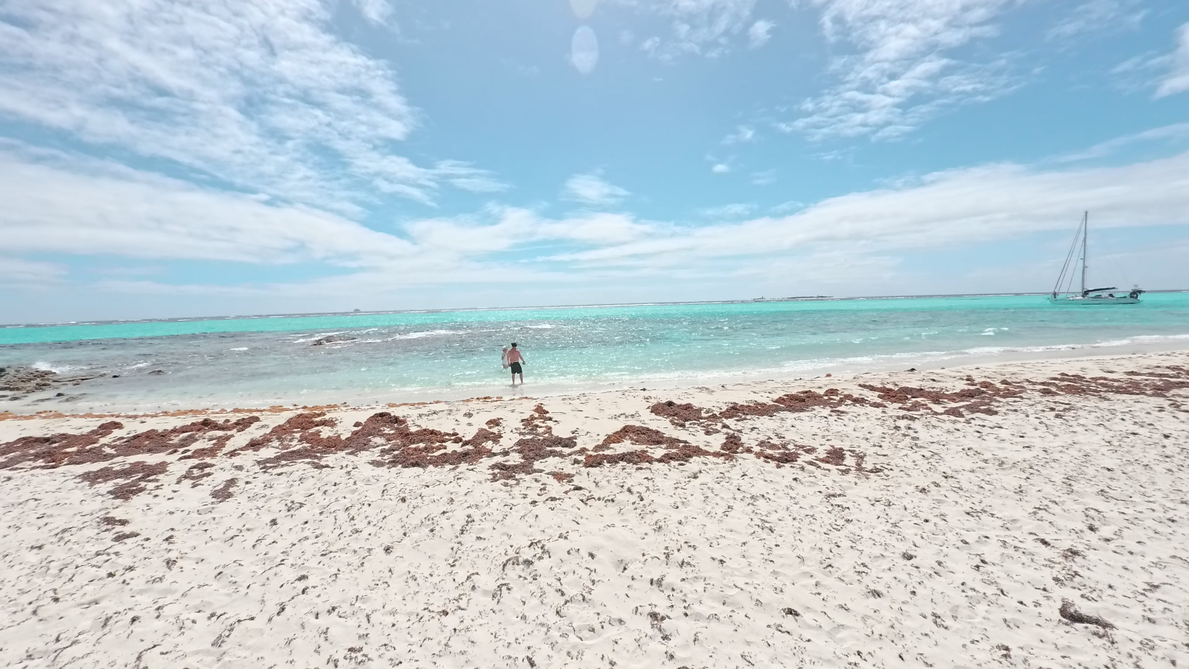 A bright beach and sailboat in the Grenadines
